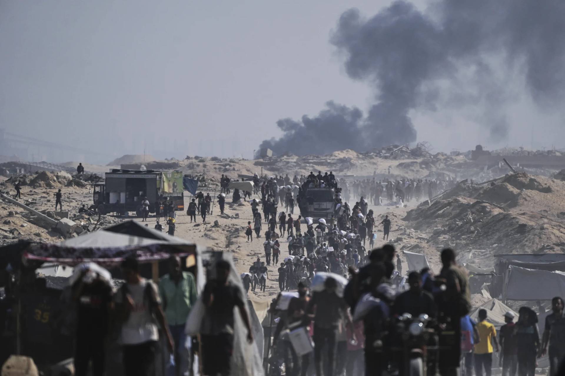 Palestinians carry sacks of flour unloaded from a humanitarian aid convoy on the outskirts of Beit Lahiya, northern Gaza Strip, Saturday, Aug, 23, 2025. (Credit: Abdel Kareem Hana/AP.)