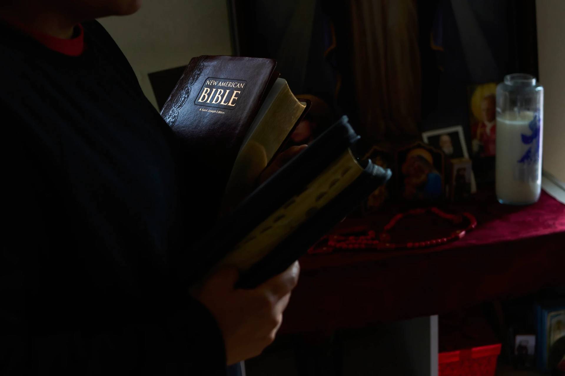 A parishioner of the Shrine of the Sacred Heart holds the Bibles of her husband who was detained by immigration agents in Washington, Friday, Oct. 10, 2025. (Credit: Luis Andres Henao/AP.)
