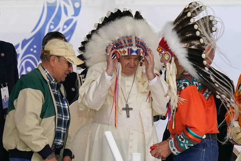Pope Francis dons a headdress during a visit with Indigenous peoples at Maskwaci, the former Ermineskin Residential School, Monday, July 25, 2022, in Maskwacis, Alberta. (Credit: Eric Gay/AP.)
