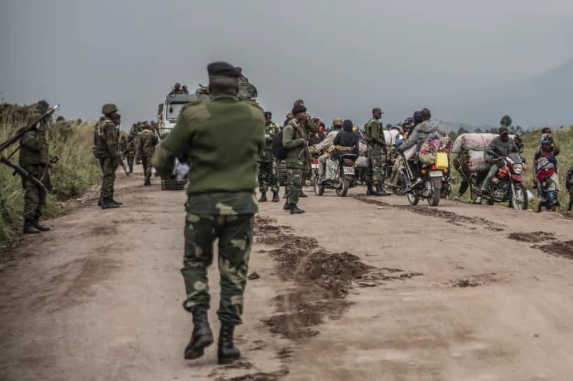 People walk on the road near Kibumba, north of Goma, Democratic Republic of Congo, as they flee fighting in North Kivu, May 24, 2022. (Credit: Moses Sawasawa/AP.)