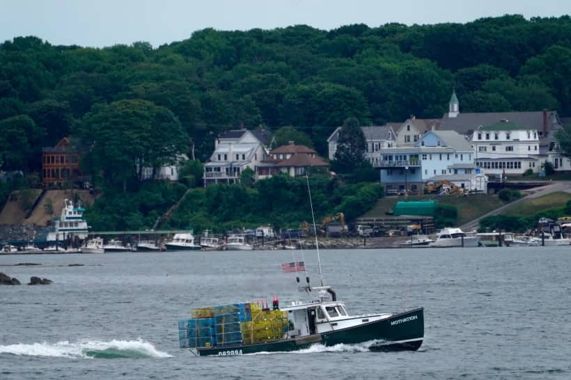 In this July 8, 2021, file photo, a lobster boat carries a heavy load of traps as it motors out to sea near Peaks Island in Portland, Maine. (Credit: Robert F. Bukaty/AP.)