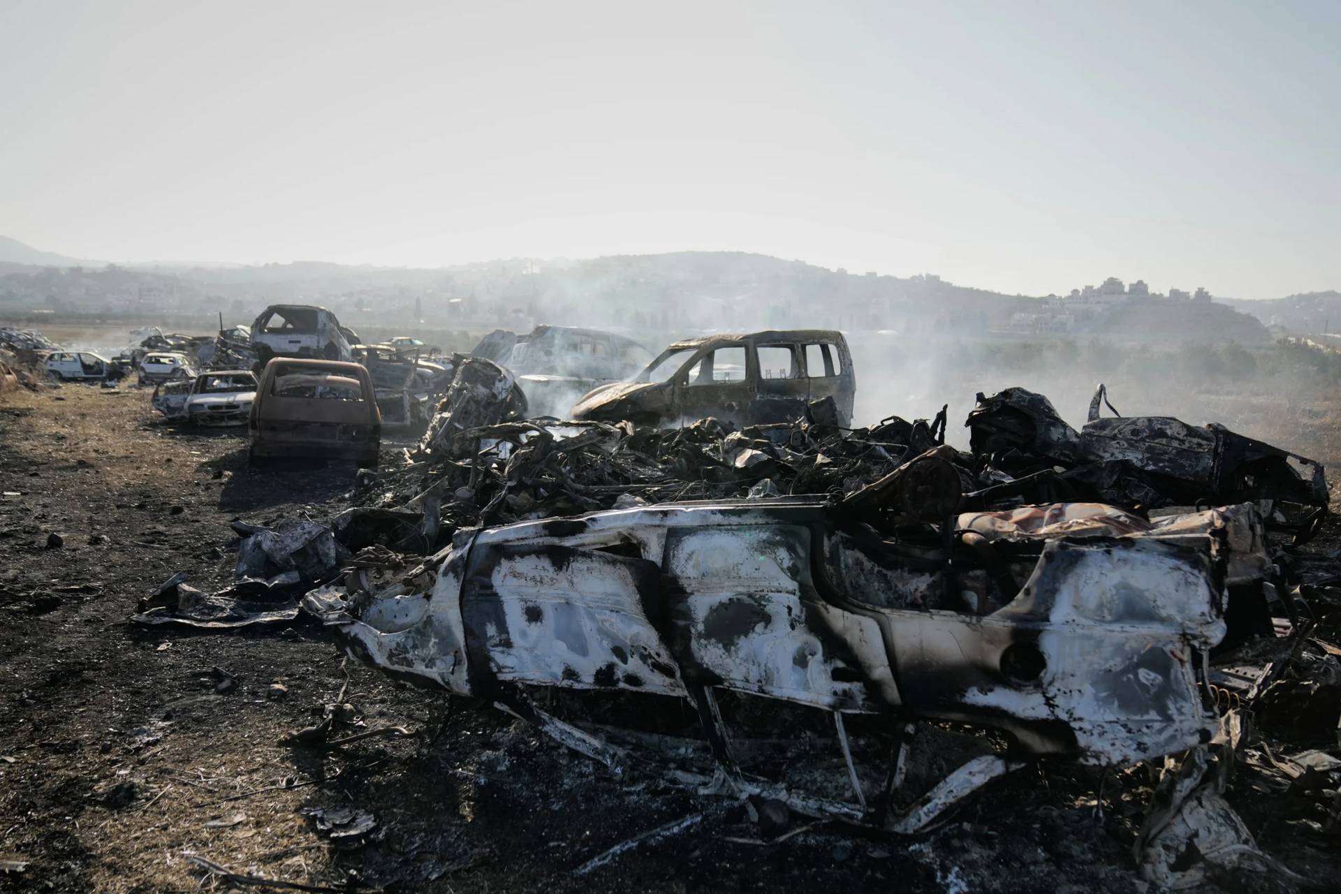 Smoke rises from scorched cars in a scrapyard that was set ablaze the night before by who local residents alleged were Israeli settlers in the town of Huwara near the West Bank city of Nablus, Friday, Nov. 21, 2025. (Credit: Nasser Nasser/AP.)
