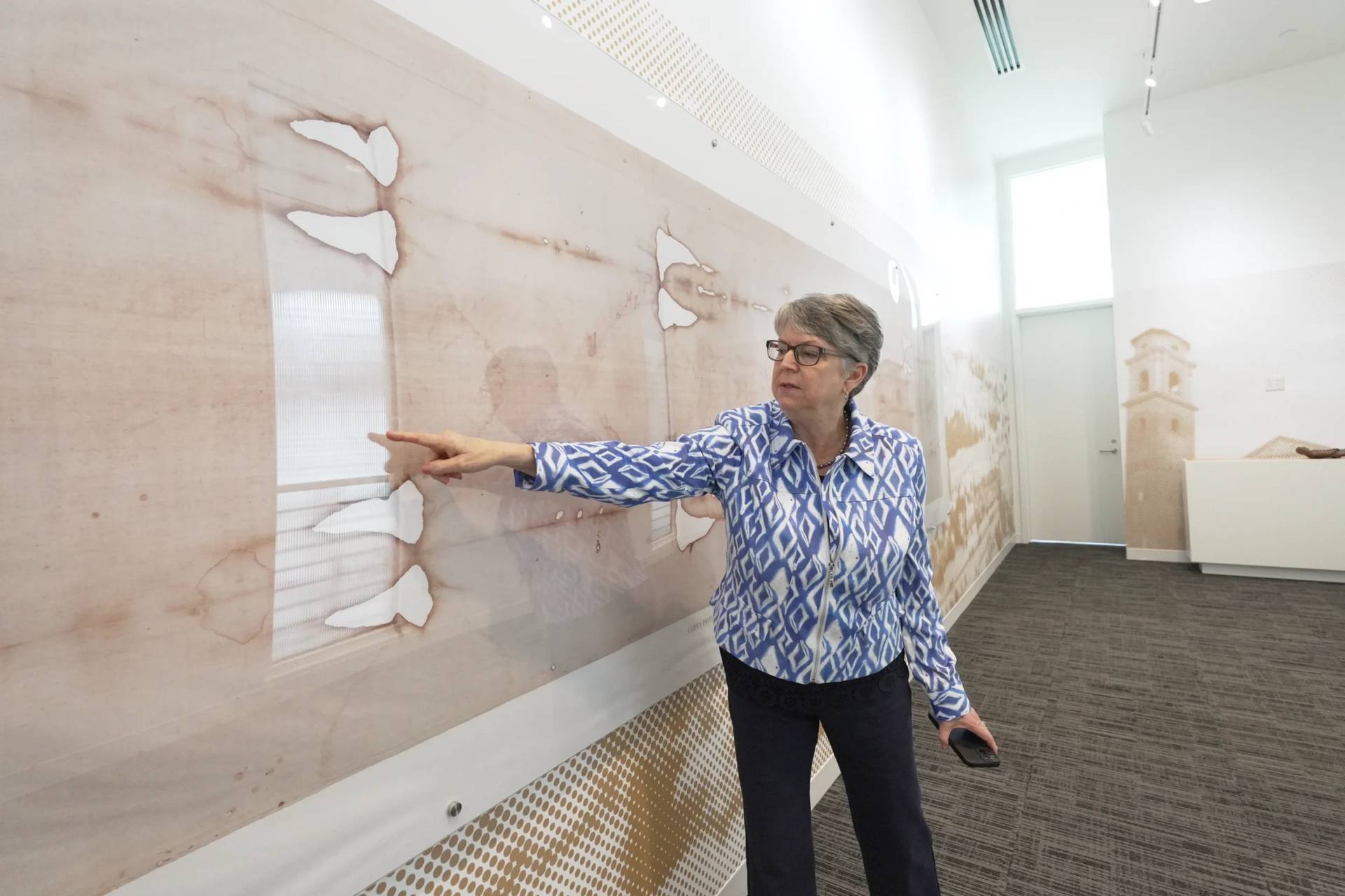 Nora Creech, director of Othonia North America, points to a replica of the Shroud of Turin at a new interactive museum dedicated to the shroud, Monday, Nov. 17, 2025, at the Christ Cathedral campus in Garden Grove, Calif. (Credit: Krysta Fauria/AP.)