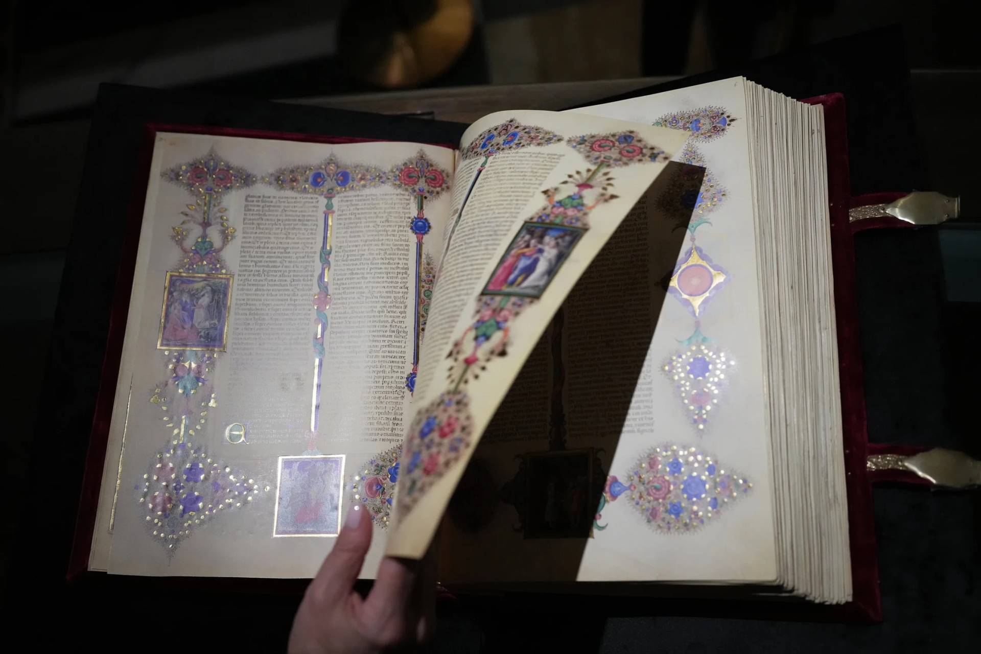 A journalist flips through a faithful reproduction of the 15th century Borso D’Este Bible, comprising two illuminated manuscripts, during its unveiling at the Italian Senate as part of the Vatican’s Holy Year celebrations in Rome, Thursday, Nov. 13, 2025. (Credit: Alessandra Tarantino/AP.)