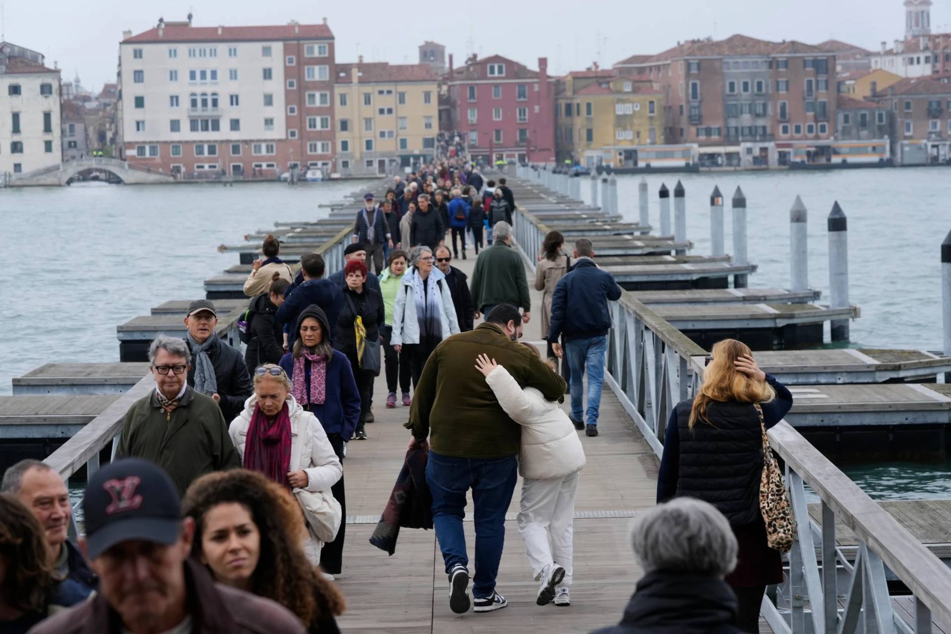 Mourners walk on the ‘Votif’ Bridge, a 407m temporary floating bridge connecting the city to the cemetery on the island of San Michele, to pay respects to their dead on All Soul’s Day, in Venice, Italy, Sunday, Nov. 2, 2025. (Credit: Luca Bruno/AP.)