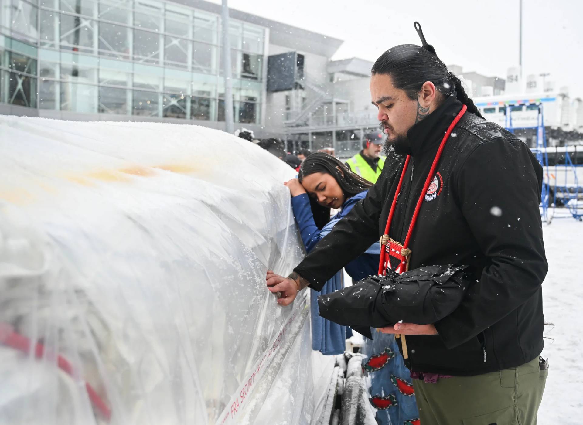 Katisha Paul of the Lil'wat and Tsartlip Nations, left, and Peyal Laceese of the Tsilhqot'in nation touch a crate containing indigenous artifacts and cultural items at Trudeau Airport in Montreal, Saturday, Dec. 6, 2025, after they were returned by the Vatican. (Credit: Graham Hughes /The Canadian Press via AP.)