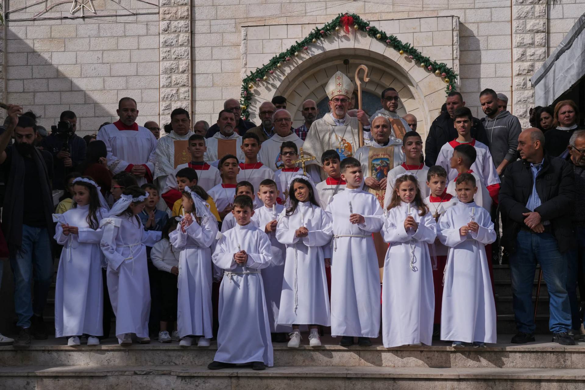Cardinal Pierbattista Pizzaballa, the Latin Patriarch of Jerusalem, poses for the photos with Palestinian parishioners after leading a mass ahead of Christmas celebrations at the Holy Family Catholic Church in Gaza City, Sunday, Dec. 21, 2025. (Credit: Jehad Alshrafi/AP.)