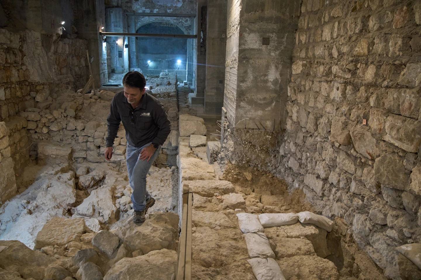 The Jerusalem Regional Archaeologist for the Israel Antiquities Authority, Dr. Amit Re'im, walks in a section of an excavation site where, according to the institution, a city wall from the Hasmonean period, dating to the late 2nd century BCE, was uncovered under the Tower of David Citadel Museum, in the Old City of Jerusalem, Monday, Dec. 8, 2025. (Credit: Leo Correa/AP.)