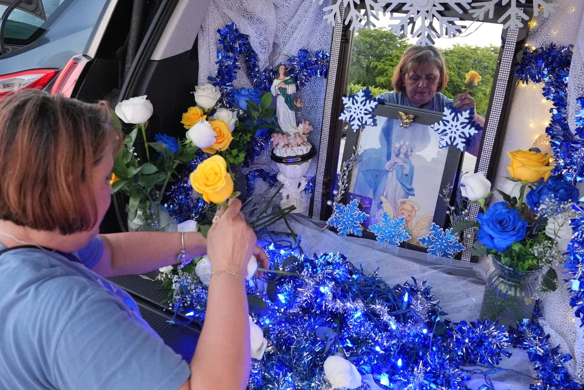 Egda Lee sets up an altar centered around a picture of the Virgin Mary which she carried with her when she crossed the U.S. border in 1984 pregnant with her son Neri Flores, as Nicaraguan parishioners of St. John Bosco Catholic Church celebrate the Dec. 8 feast of the Immaculate Conception, Sunday, Dec. 7, 2025, in Miami. (Credit: Rebecca Blackwell/AP.)
