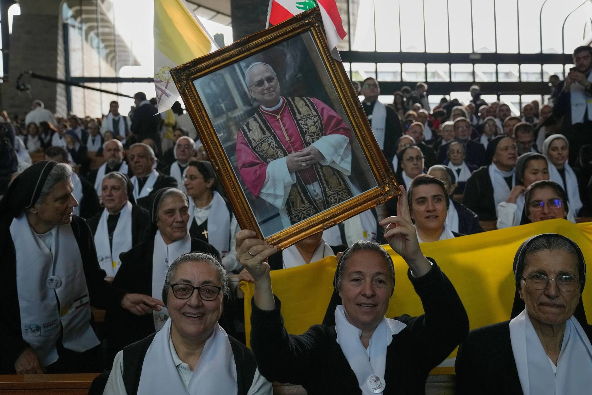 A nun holds up a portrait of Pope Leo XIV where he will meet with bishops, priests, consecrated persons and pastoral workers at the Catholic basilica of Harissa, Lebanon Monday, Dec. 1, 2025. (Credit: Hussein Malla/AP.)