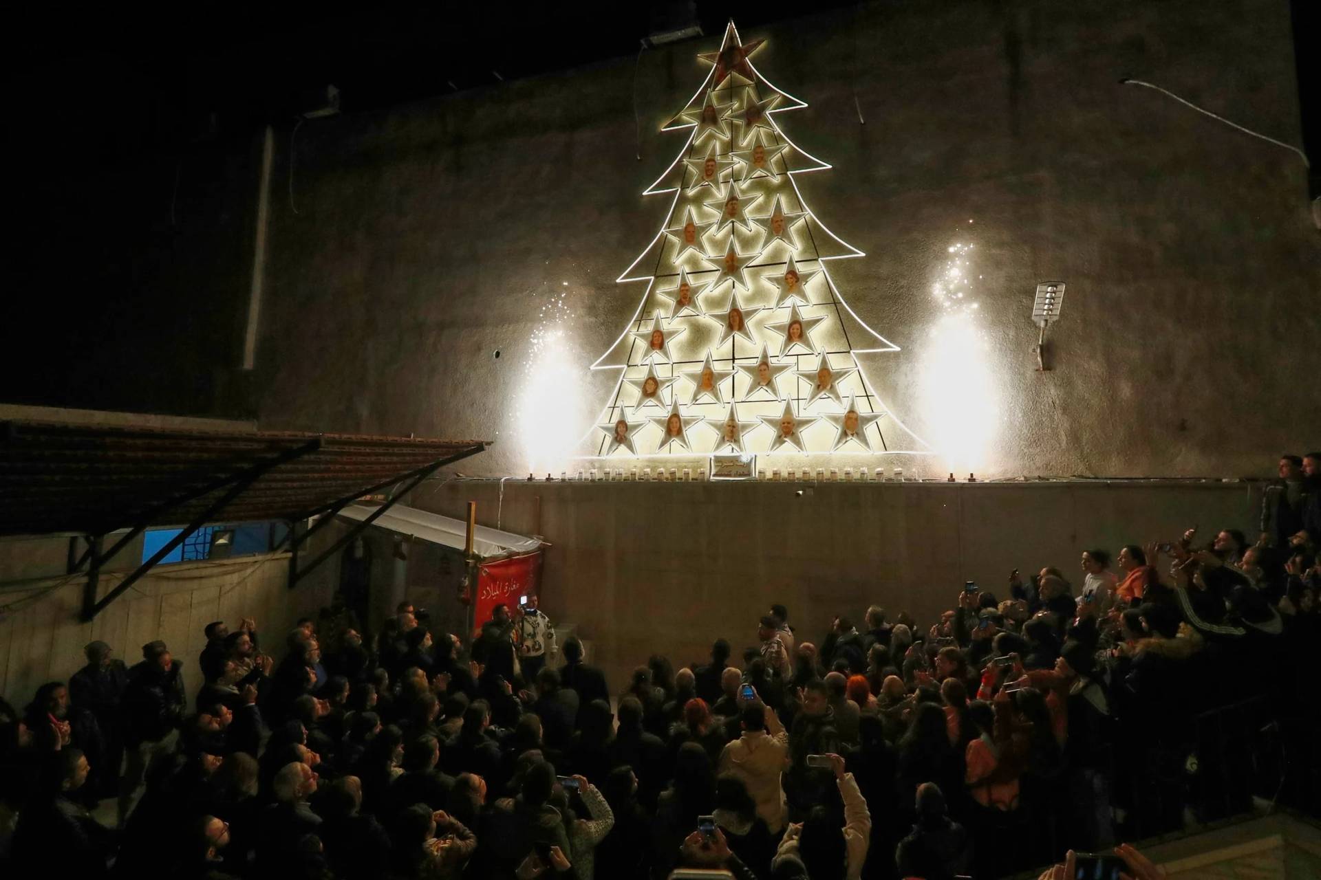 People attend the lighting of a Christmas tree at the Greek Orthodox Mar Elias Church, months after the church was the site of a deadly suicide bombing, in the Dweila neighborhood of Damascus, Syria, Tuesday, Dec. 23, 2025.(Credit: Omar Sanadiki/AP.)