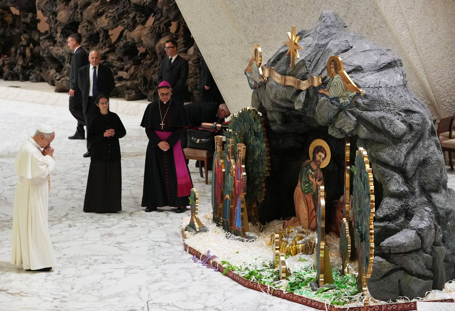 Pope Leo XIV, front left, prays in front of a nativity scene set in the Paul VI Hall during an audience with donors of the Christmas tree and of the nativity scenes, at the Vatican Monday, Dec. 15, 2025. (Credit: Alessandra Tarantino/AP.)