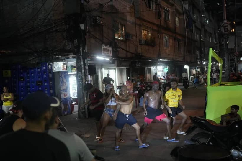 Illuminated by a motorcycle headlight, youth perform a street dance known as passinho in the Rocinha favela of Rio de Janeiro, Brazil, April 11, 2024. (Credit: Silvia Izquierdo/AP.)