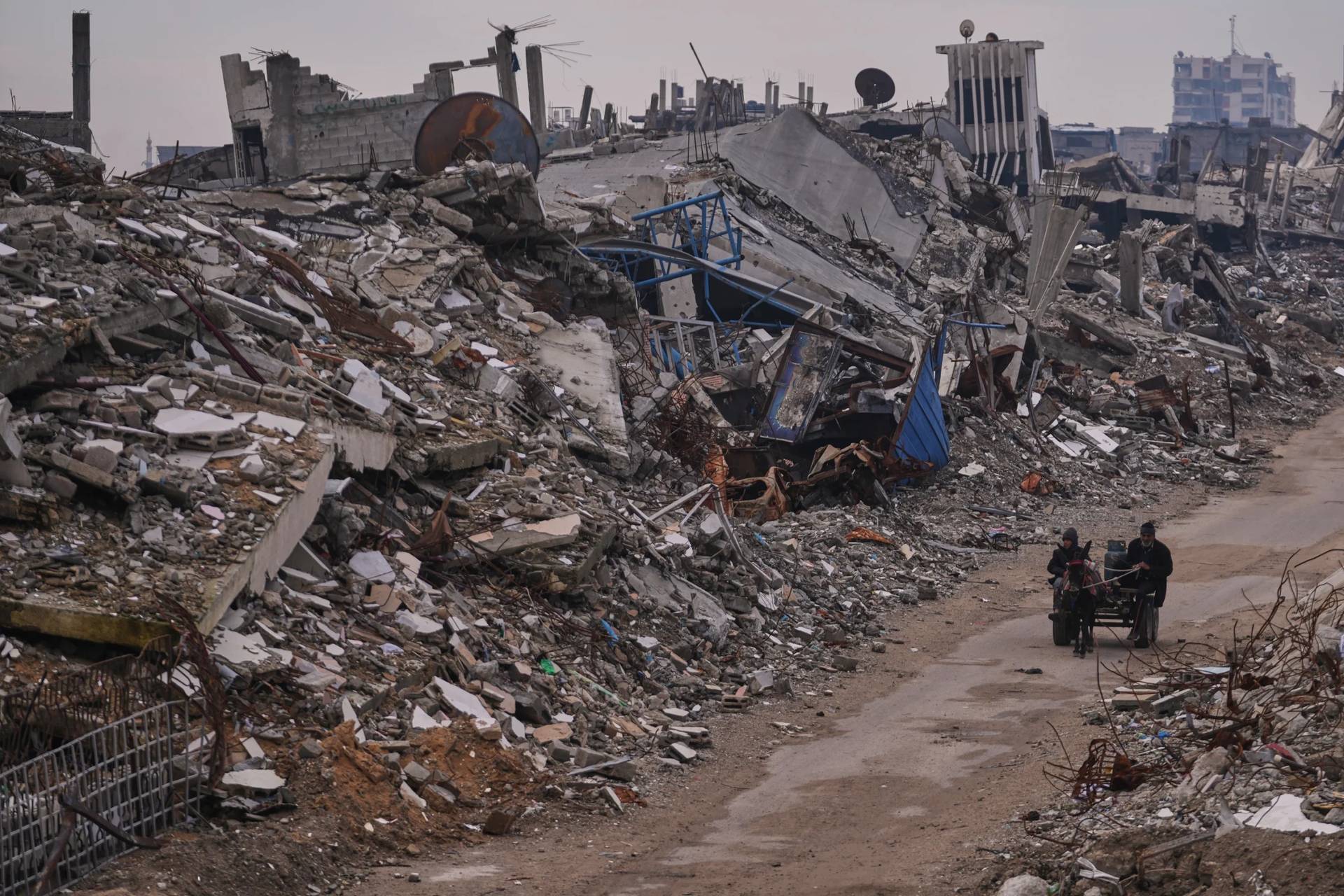 Palestinians pass along a street surrounded by buildings destroyed during Israeli air and ground operations in the Sheikh Radwan neighborhood, in Gaza City, Dec. 30, 2025. (Credit: Abdel Kareem Hana/AP.)