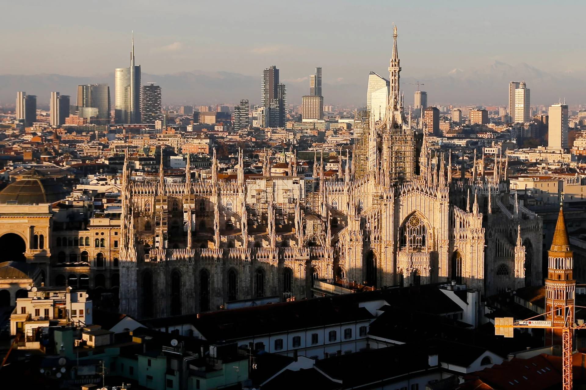 The pinnacles of the Duomo cathedral are lit by the afternoon declining sun and backdropped by the new Business Center in Milan, northern Italy, Jan. 4, 2017. (Credit: Luca Bruno/AP.)