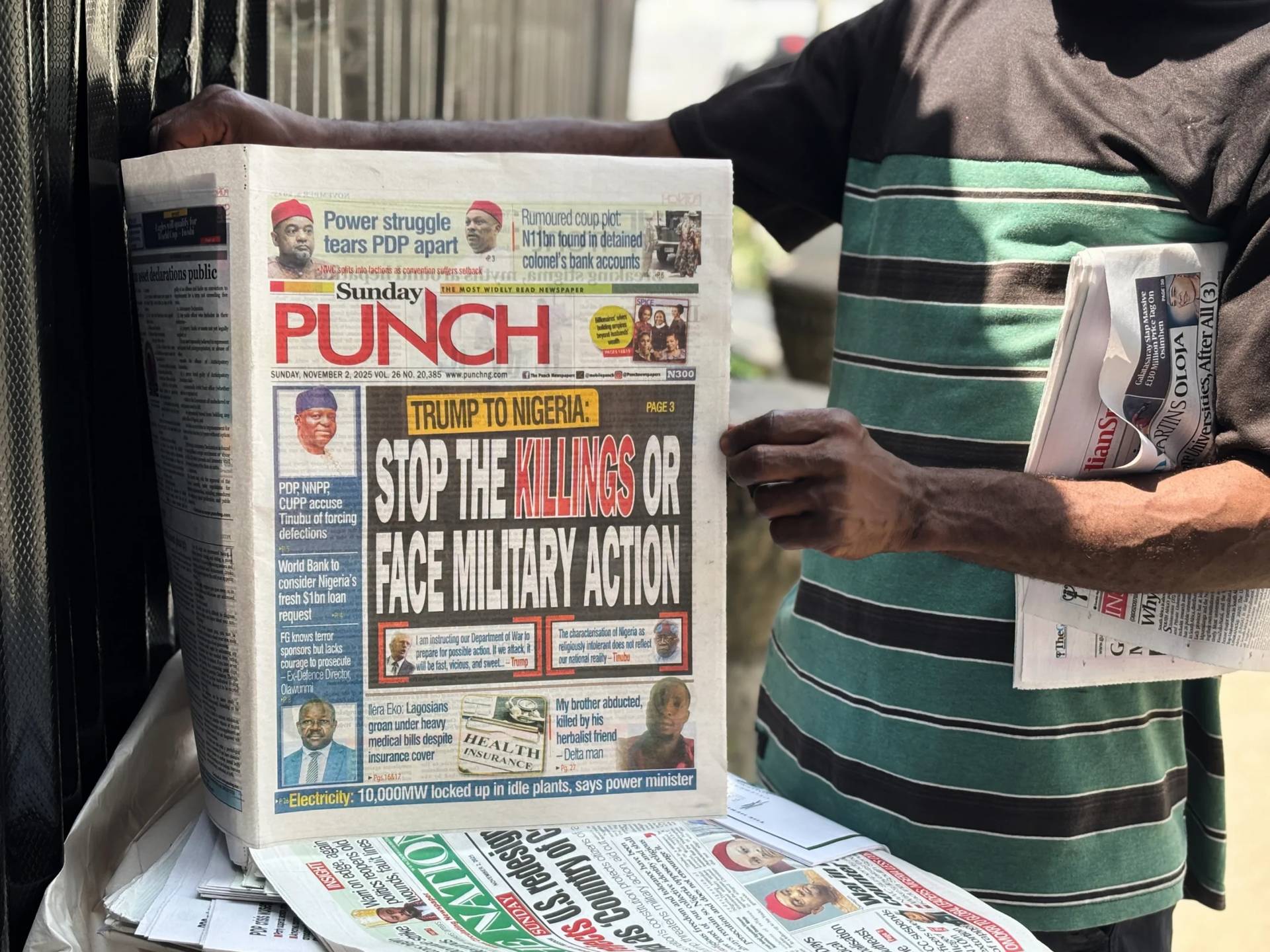 A vendor sells local newspapers with headlines referring to US President Donald Trump’s comments about Nigeria, on the street of Lagos, Nigeria, Sunday, Nov. 2, 2025. (Credit: Sunday Alamba/AP.)