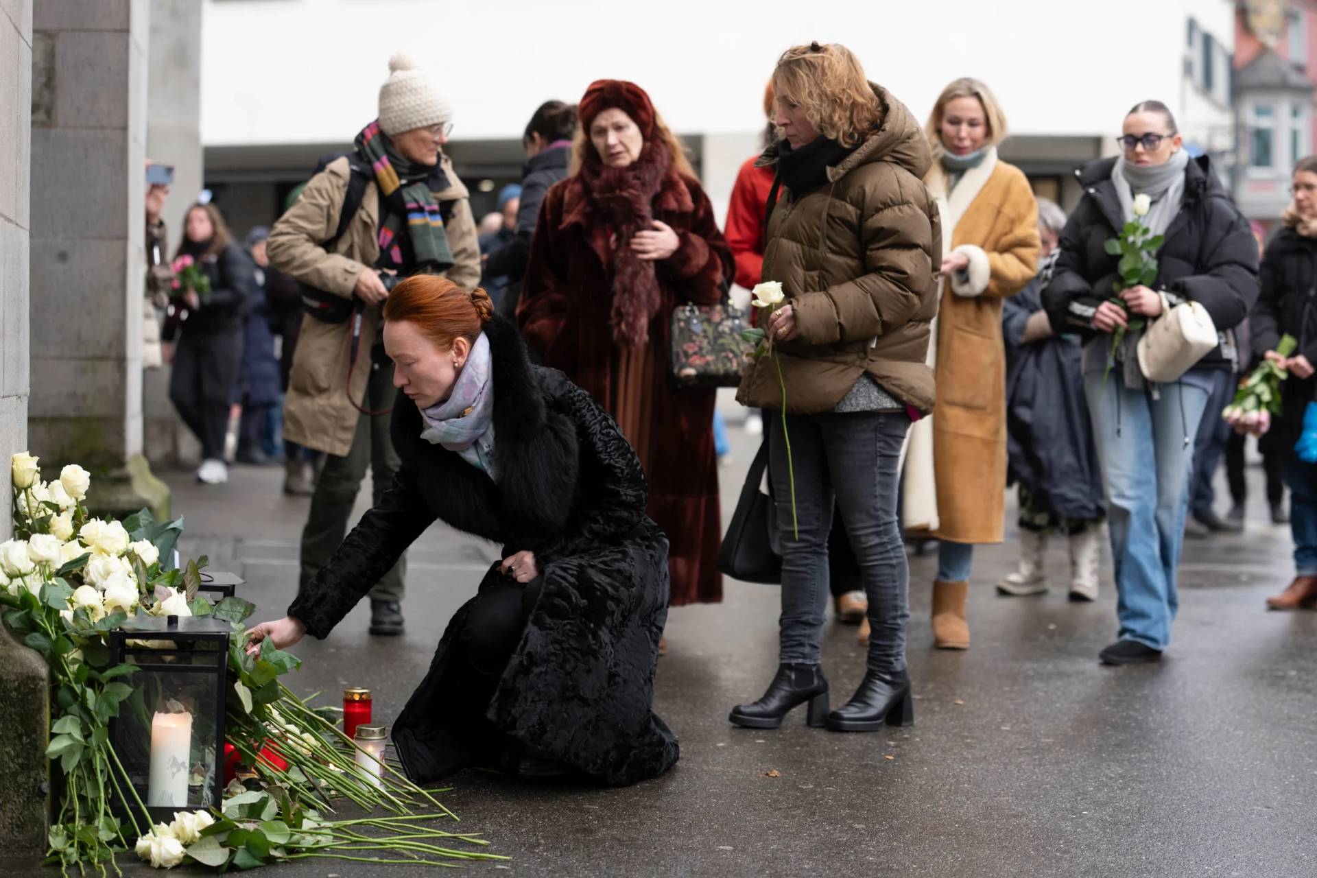 People lay down flowers in tribute to the victims after the official commemorative ceremony for the victims of the deadly fire at the "Le Constellation" bar in Crans-Montana, in Zurich, Switzerland, Friday, Jan. 9, 2026. (Credit: Claudio Thoma/Keystone/Pool via AP.)