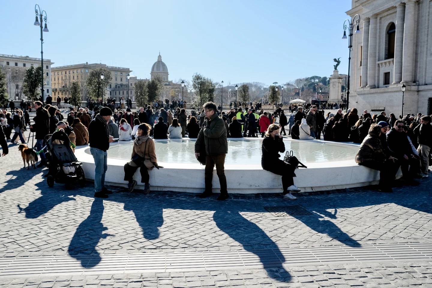People sit on a fountain after the inauguration of the new design of Piazza Pia, a pedestrian piazza at the end of the Via della Conciliazione boulevard, opposite St. Peter's Basilica, Thursday, Dec. 26, 2024. (Credit: Mauro Scrobogna/LaPresse via AP.)