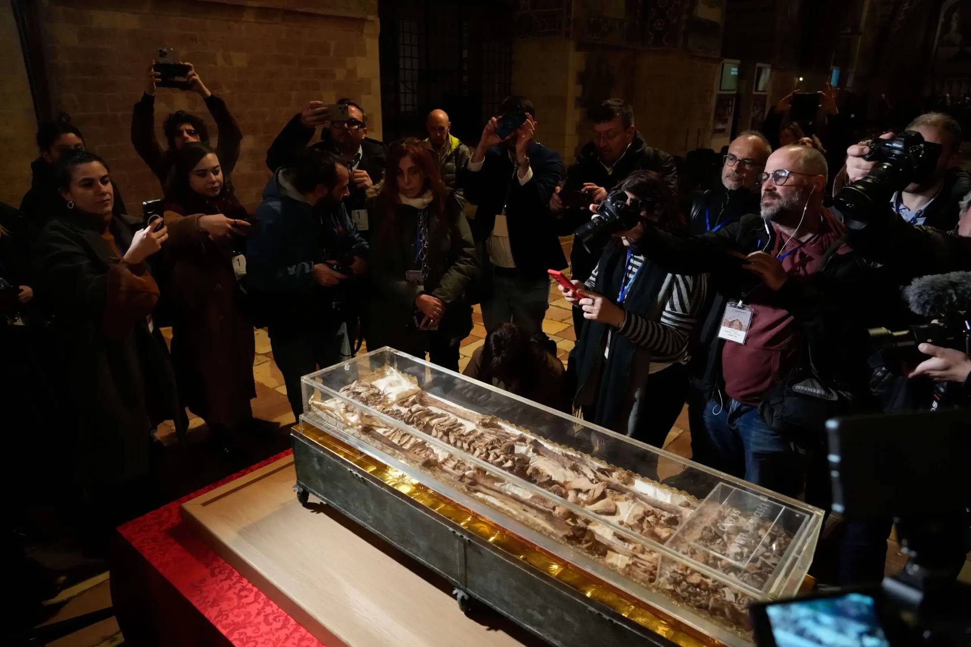 Journalists record the remains of Francis of Assisi inside the Basilica of St. Francis of Assisi in Assisi, Italy, Saturday, Feb. 21, 2026, on the eve of a public exposition beginning Feb. 22 to mark the 800th anniversary of his death in 1226. (Credit: Gregorio Borgia/AP.)