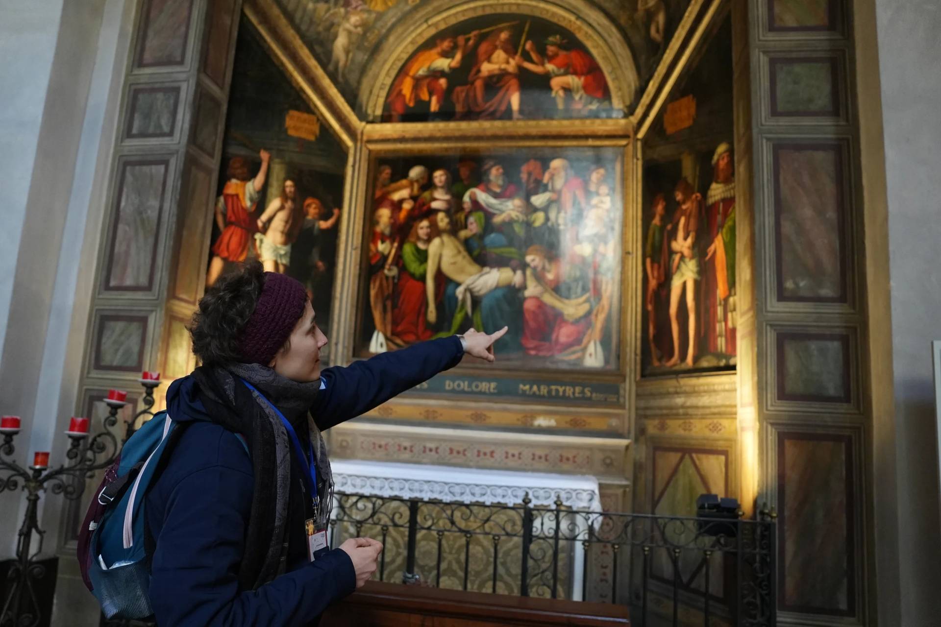 Sara Cainarca, a volunteer with the “La Via della Bellezza,” or “The Path of Beauty,” initiative, gestures toward a fresco in the church of San Giorgio al Palazzo, in Milan, Italy, Wednesday, Feb. 18, 2026. (Credit: María Teresa Hernández/AP.)
