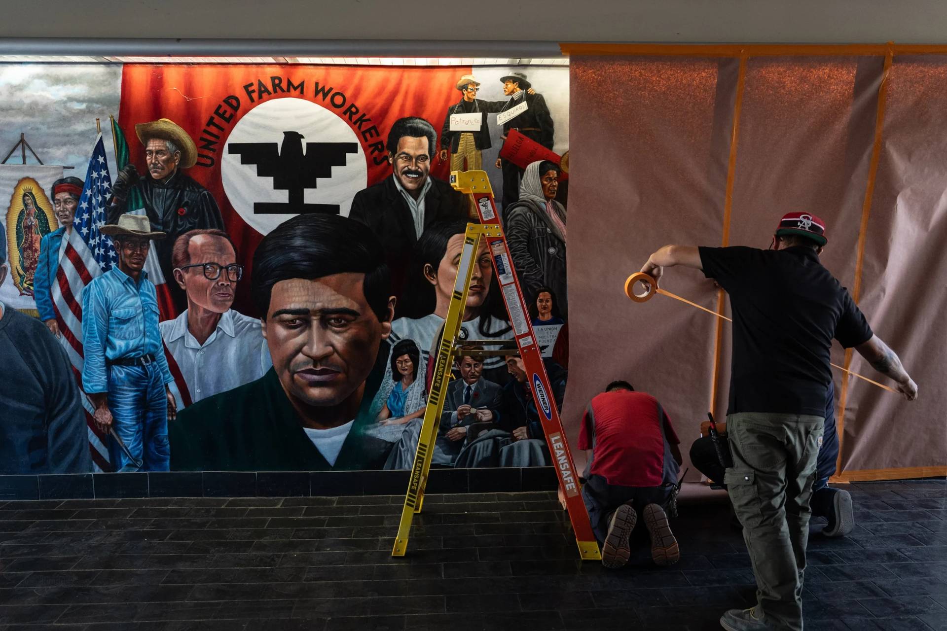 Workers cover a mural by Emigdio Vasquez featuring César Chavez at Santa Ana College in Santa Ana, California on March 19, 2026. (Credit: Jae C. Hong/AP.)