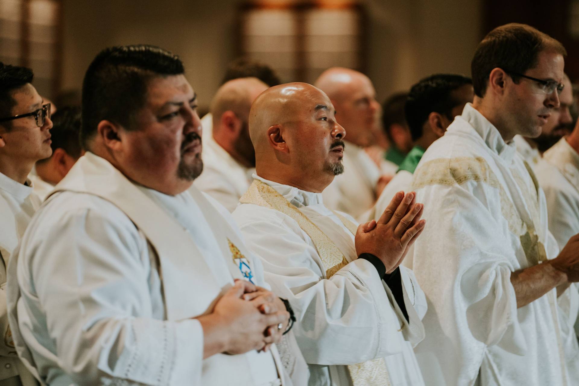 Catholic priests stand together celebrating Mass. (Credit: Amazing Parish.)