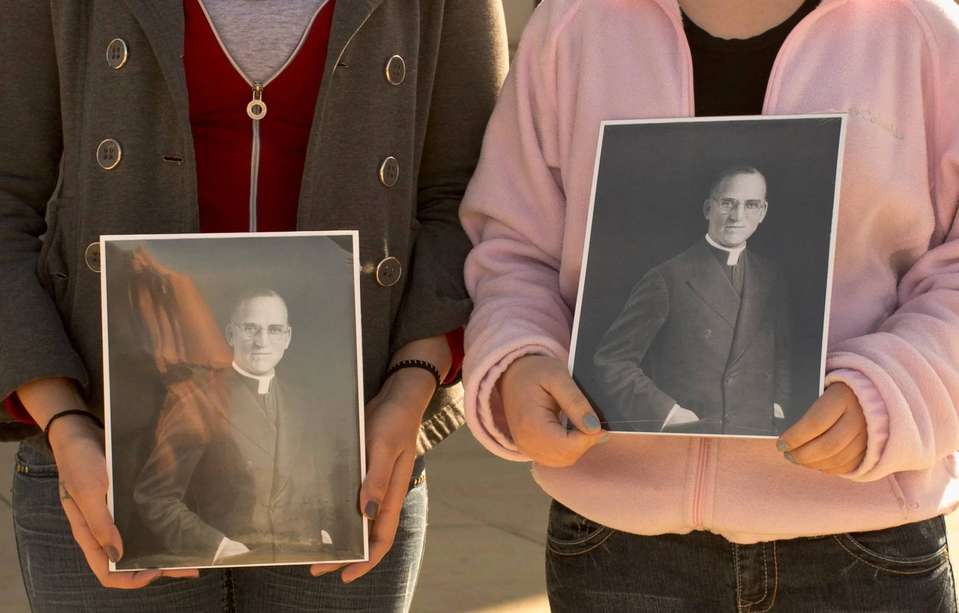 Boys Town students hold portraits of Boys Town founder Father Edward Flanagan outside St. Cecilia Cathedral in Omaha, Neb., Feb. 27, 2012. (Credit: Nati Harnik/AP.)