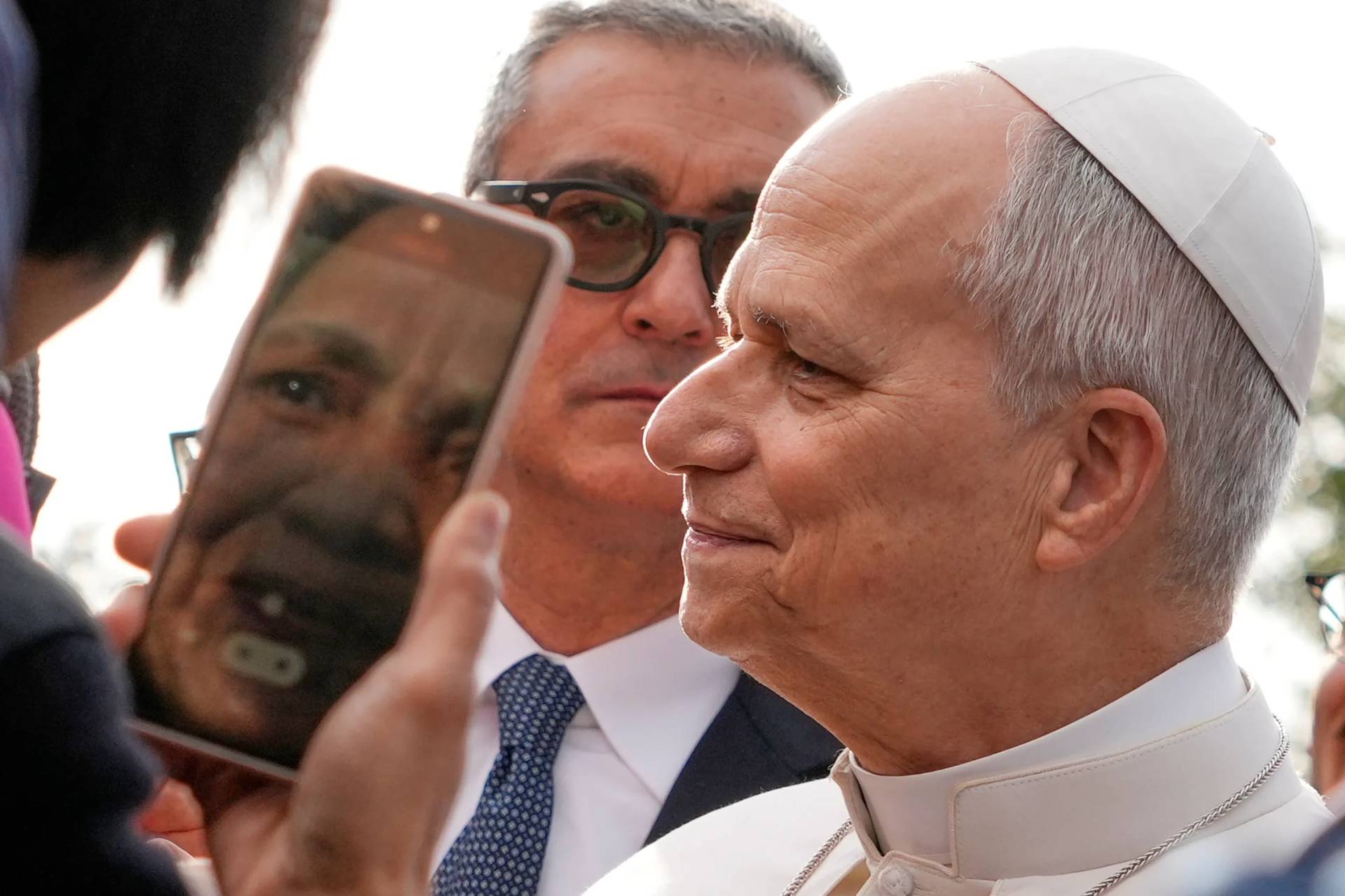 The head of Vatican Security, Gianluca Gauzzi Broccoletti, center, follows Pope Leo XIV as he visits the parish complex of Santa Maria della Presentazione on the outskirts of Rome, Sunday, March 8, 2026. (Credit: Gregorio Borgia/AP.)