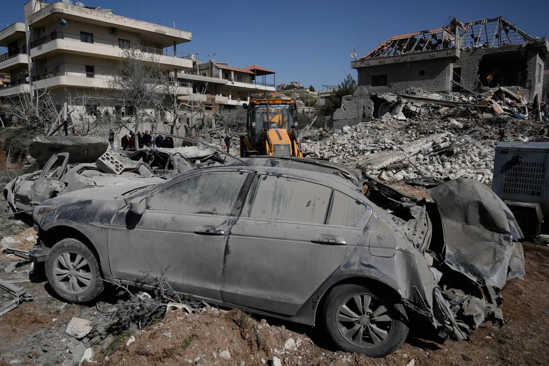 People gather near a building destroyed in an Israeli strike in the village of Bednayel in eastern Lebanon, Saturday, Feb. 21, 2026. (Credit: Bilal Hussein/AP.)