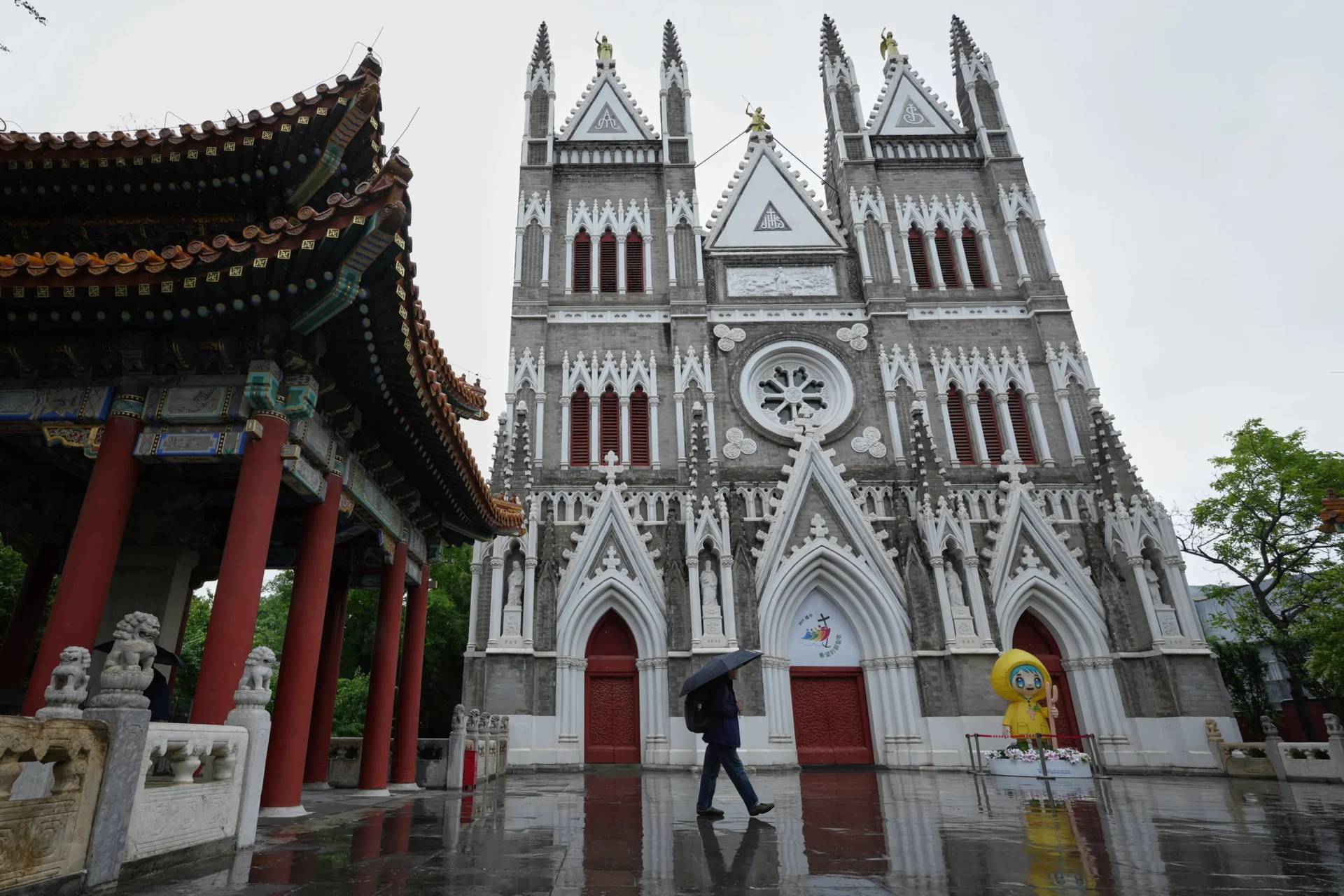 A man walks out from a pavilion near the Xishiku Catholic Church during a rainy day in Beijing, May 9, 2025. (Credit: Andy Wong/AP.)