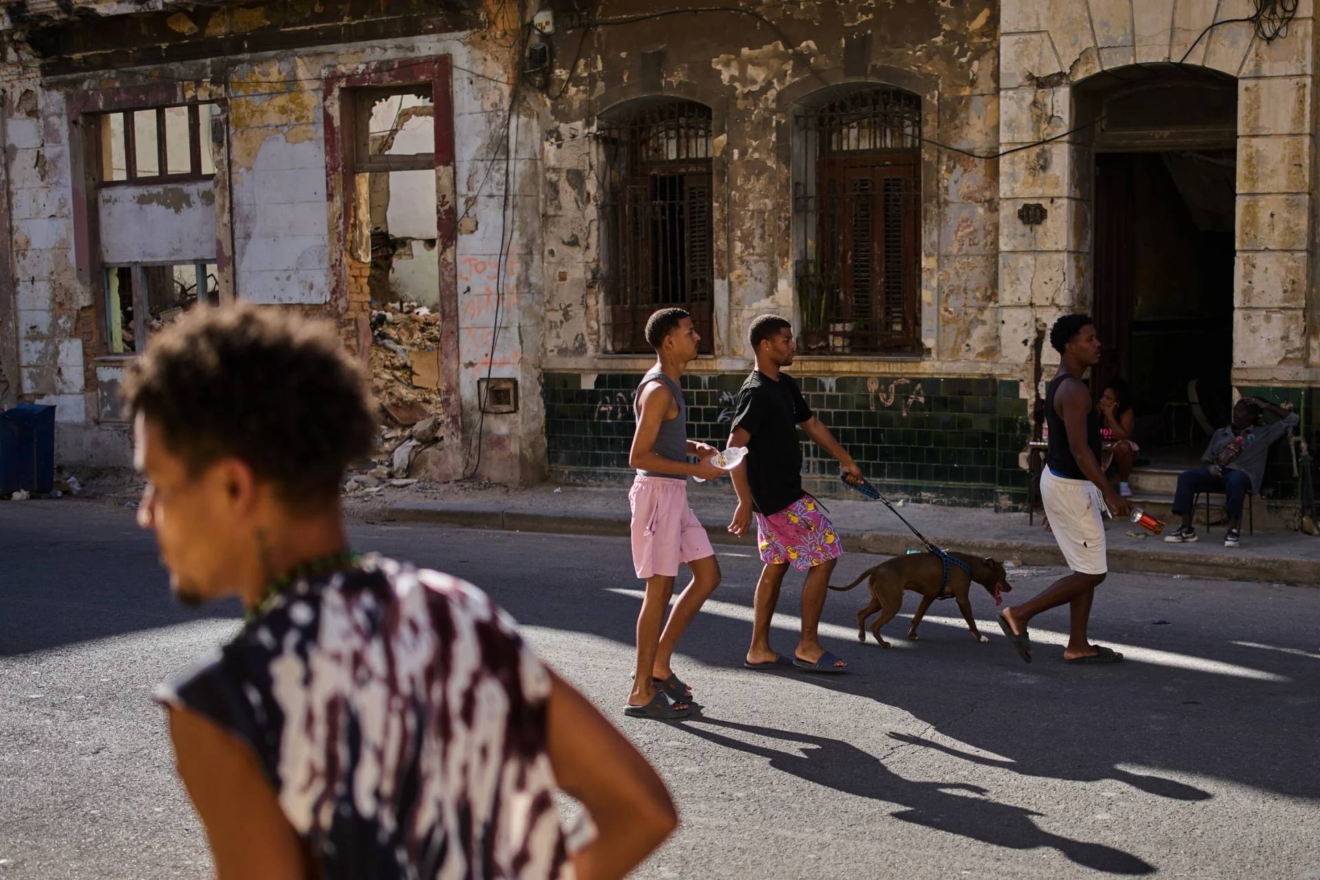 People walk a dog on a street in Havana, Cuba, on March 25, 2026. (Credit: Ramon Espinosa/AP.)