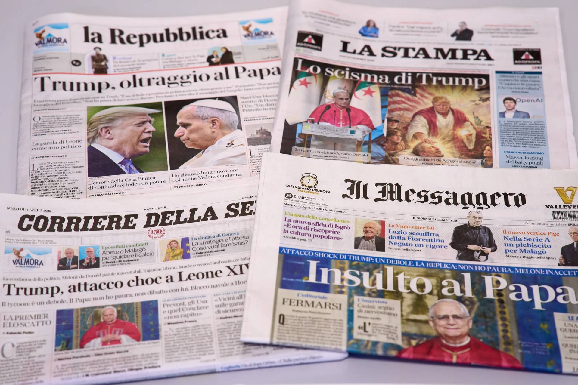 This picture, taken Tuesday, April 14, 2026, shows the front pages of some Italian newspapers reporting on comments by U.S. President Donald Trump about Pope Leo XIV, with headlines using words such as “outrage”, “shock attack”, “insult”, and Trump’s schism”. (Credit: Domenico Stinellis/AP.)