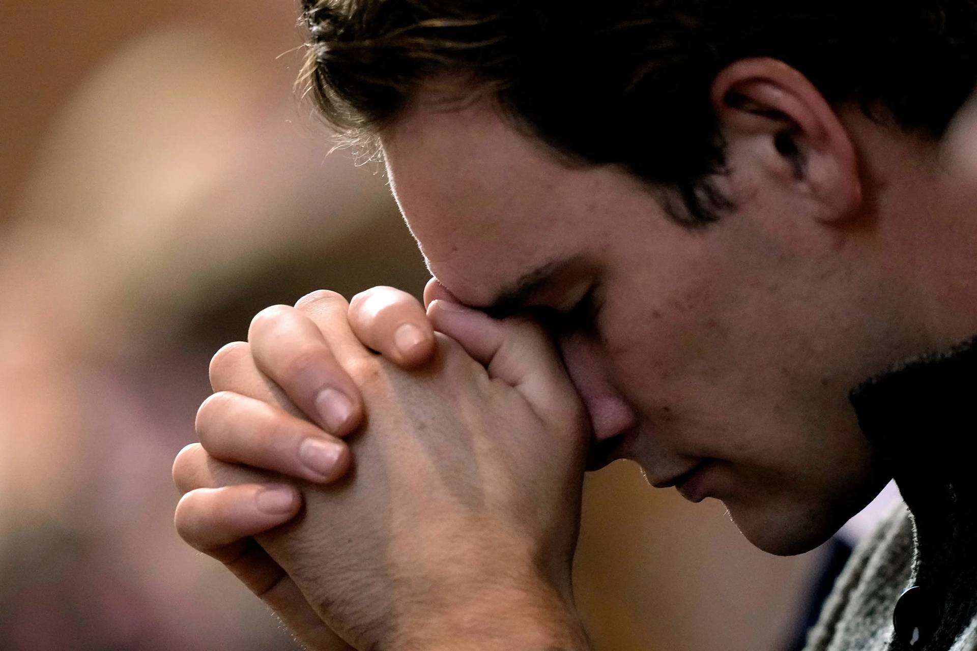 A man prays during Catholic Mass at Benedictine College, Oct. 29, 2023, in Atchison, Kan. (Credit: Charlie Riedel/AP.)