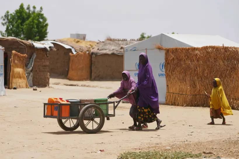 A woman and young girl displaced from Boko Haram attacks push a cart in Dikwa, Borno province, north east Nigeria, Tuesday, April 29, 2025. (Credit: Sunday Alamba/AP.)