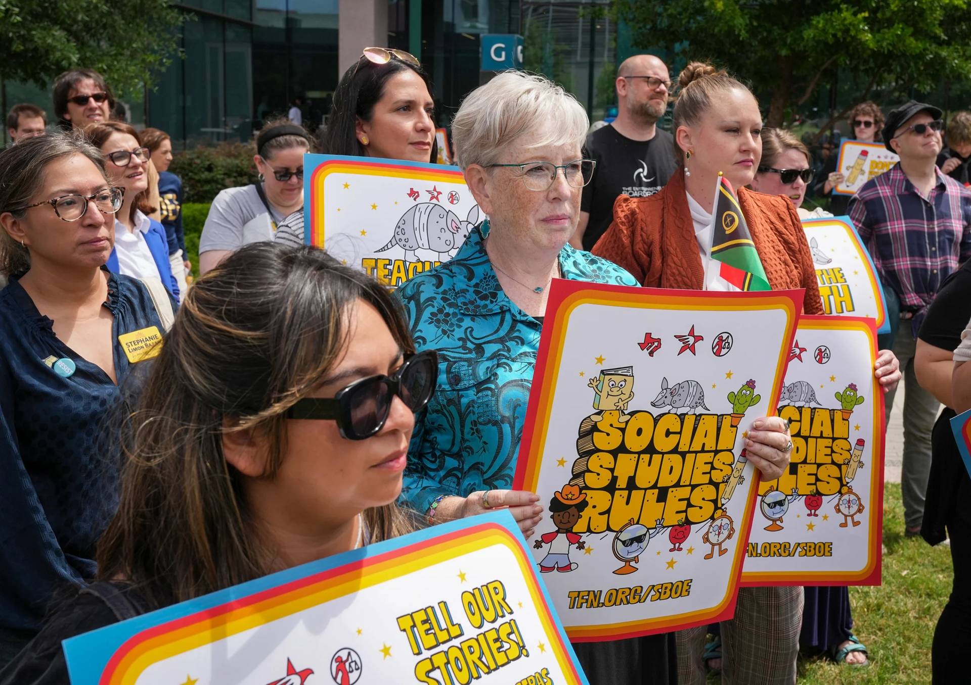Karen Prewitt of Mission holds a sign reading "Social studies rules" during a rally on the Capitol Mall outside the Barbara Jordan State Office Building, where the State Board of Education meets, Tuesday, April 7, 2026, in Austin, Texas. (Credit: Jay Janner/Austin American-Statesman via AP.)