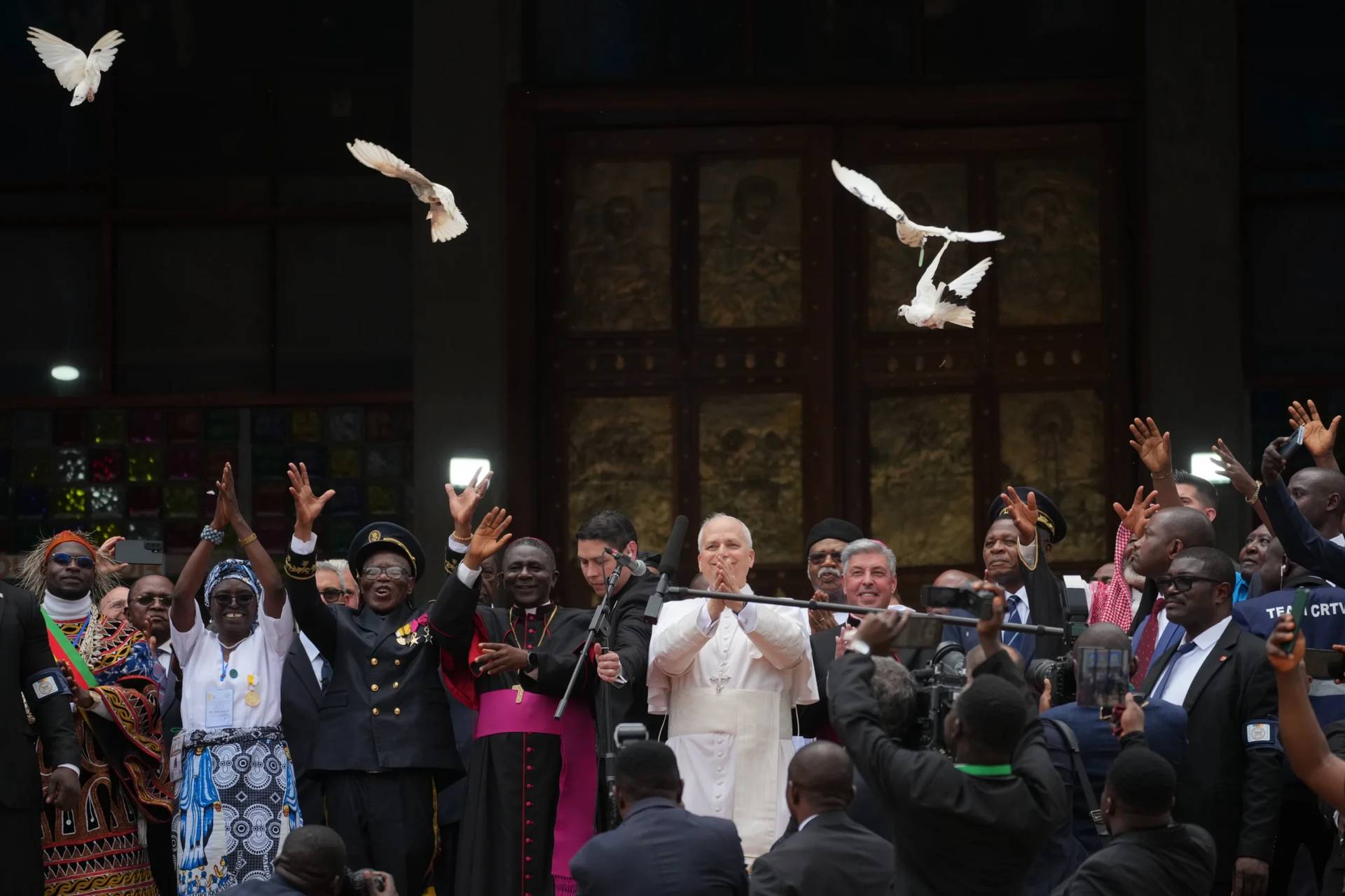 Pope Leo XIV, with the Archbishop of Bamenda, Andrew Nkea Fuanya, left, frees a white dove at the end of a meeting for peace at Saint Joseph's Cathedral in Bamenda, Cameroon, with the local community Thursday, April 16, 2026, on the fourth day of his 11-day pastoral visit to Africa. (Credit: Andrew Medichini/AP.)