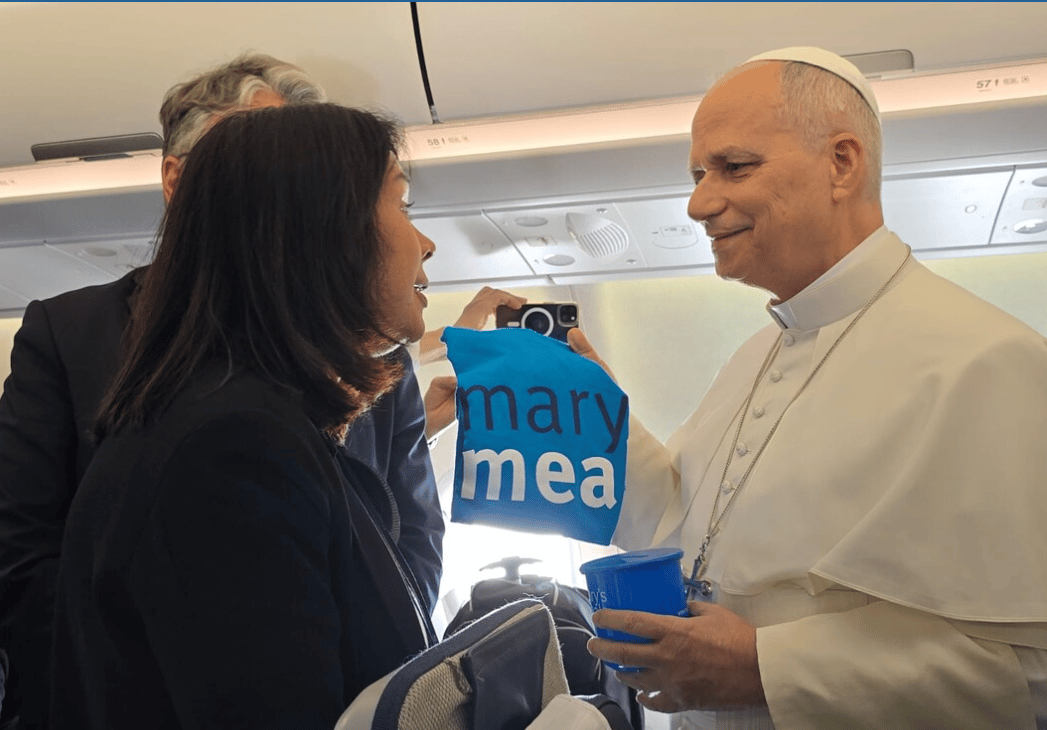 On the papal plane, Pope Leo receives a shirt for Mary's Meals. (Credit: Mary's Meals.)