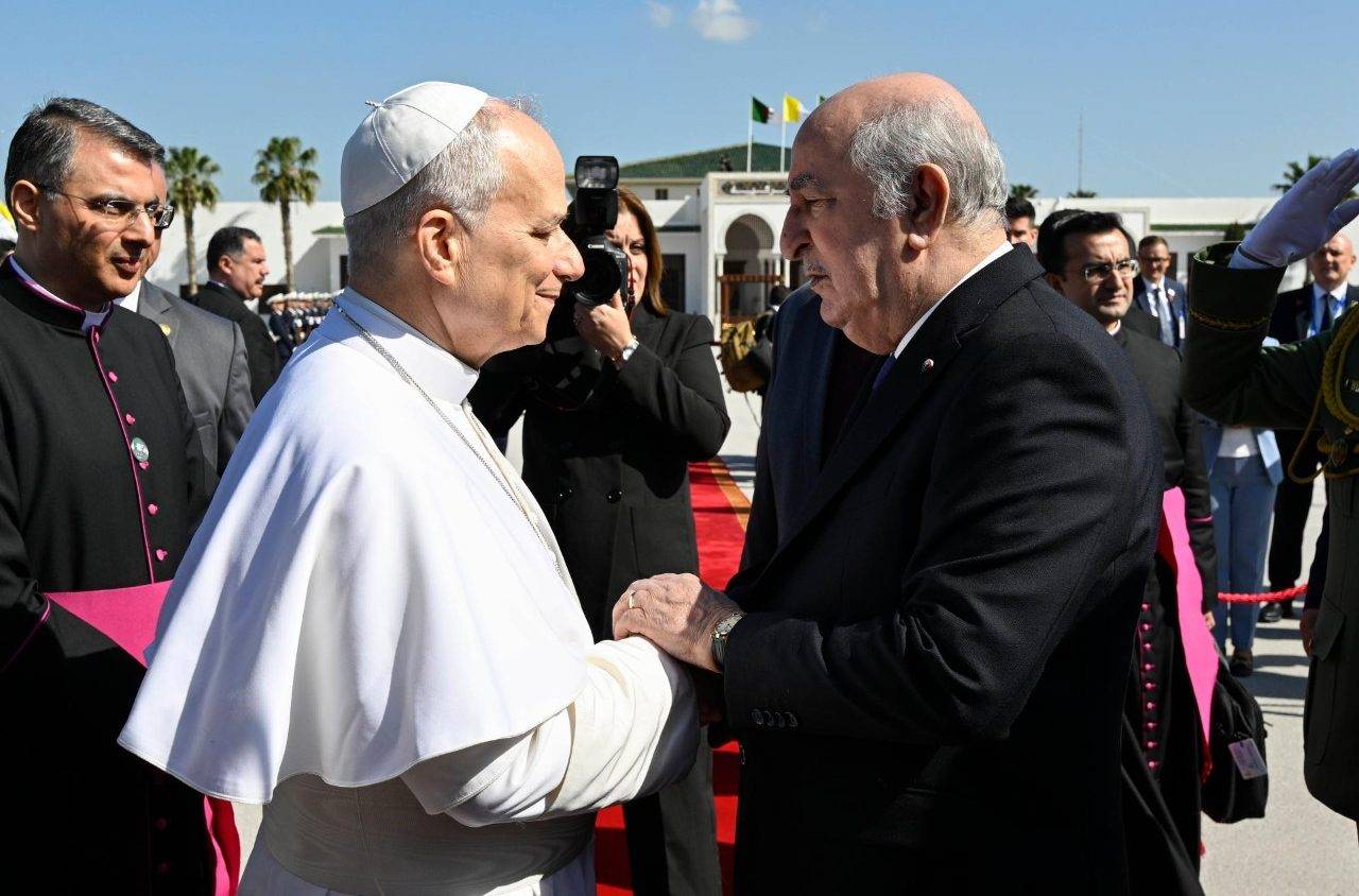 Pope Leo XIV shakes hands with Algerian President Abdelmadjid Tebboune on Algiers’s “Houari Boumédiène” International Airport on April 15, 2026. (Credit: Vatican Media.)