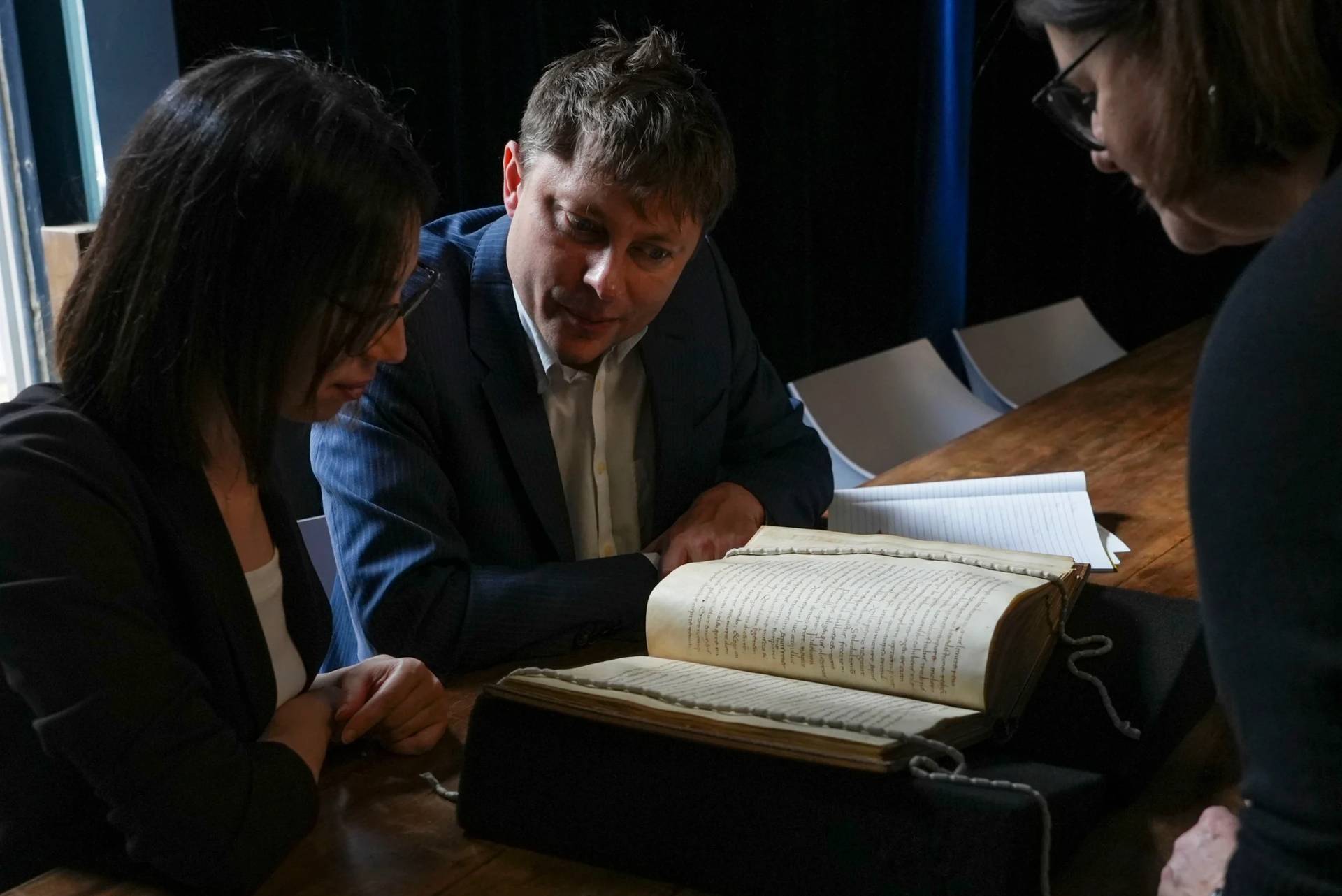 From left, Elisabetta Magnanti and Mark Faulkner from Dublin's Trinity College and Valentina Longo of Rome's National Central Library look at a manuscript containing a rare, long-lost copy of Caedmon's Hymn, the first poem ever to be written down in Old English, at Rome's National Library, Thursday, May 8, 2026. (Credit: Andrea Rosa/AP.)