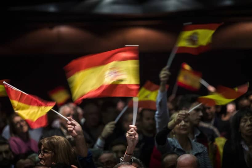 Supporters of Spain’s far-right Vox party wave flags during a rally in Murcia, Spain, Wednesday Nov. 14, 2018. (Credit: Emilio Morenatti/AP.)