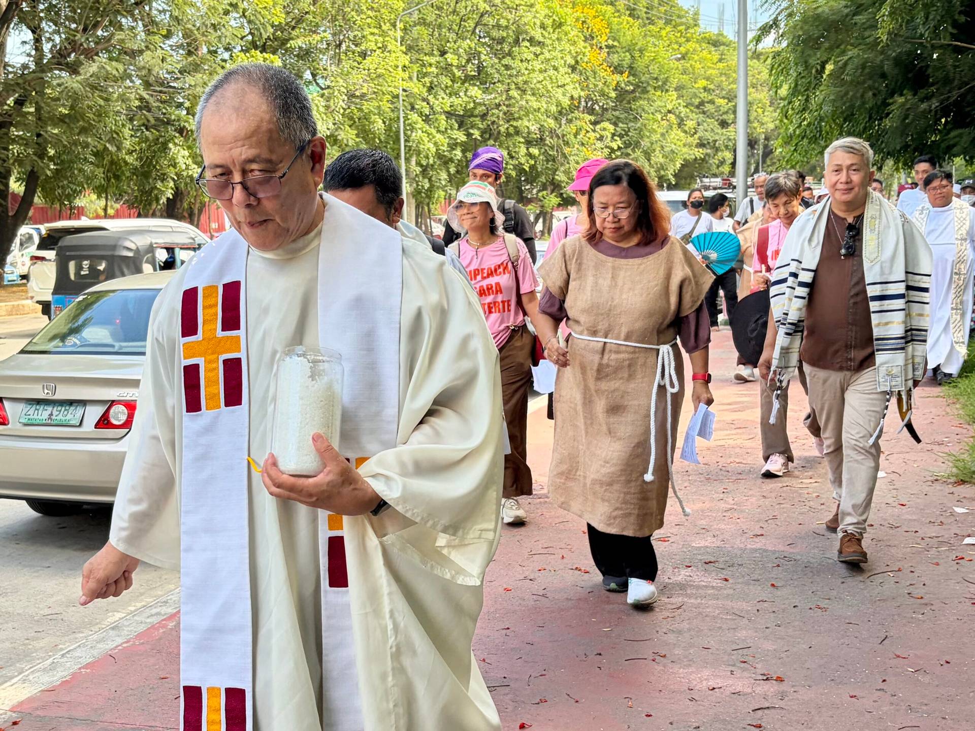 Filipino activist priest Father Robert Reyes holds a jar of exorcised salt meant to be sprinkled around the Philippine Senate building, July 4, 2026. (Credit: Paterno Esmaquel II.)