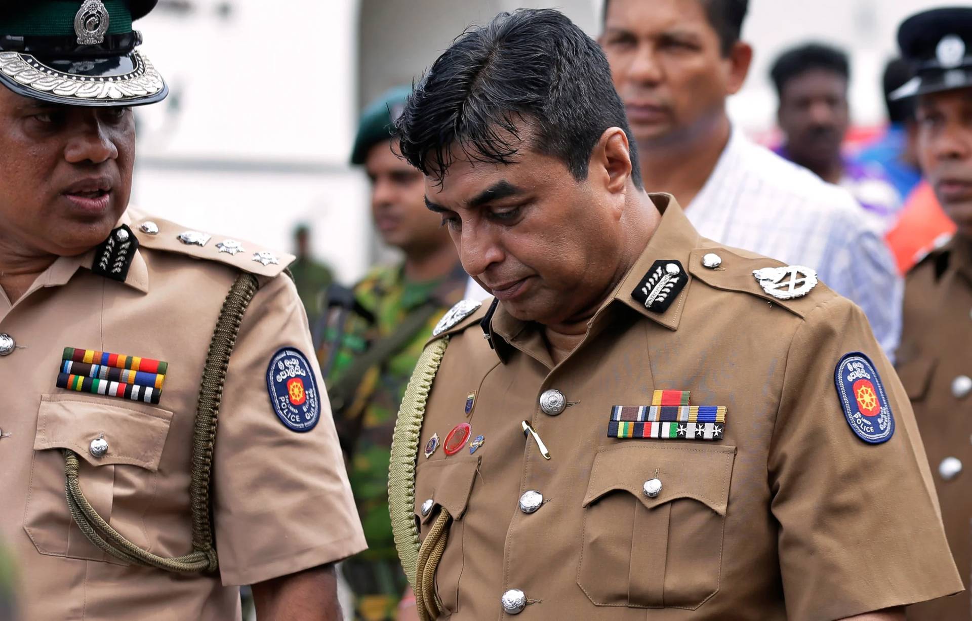 Sri Lanka police chief Pujith Jayasundara, left, leaves after an inspection of St. Anthony's Church, one of the sites of the Easter Day Explosions in Colombo, Sri Lanka, on April 21, 2019. (Credit: Eranga Jayawardena/AP.)
