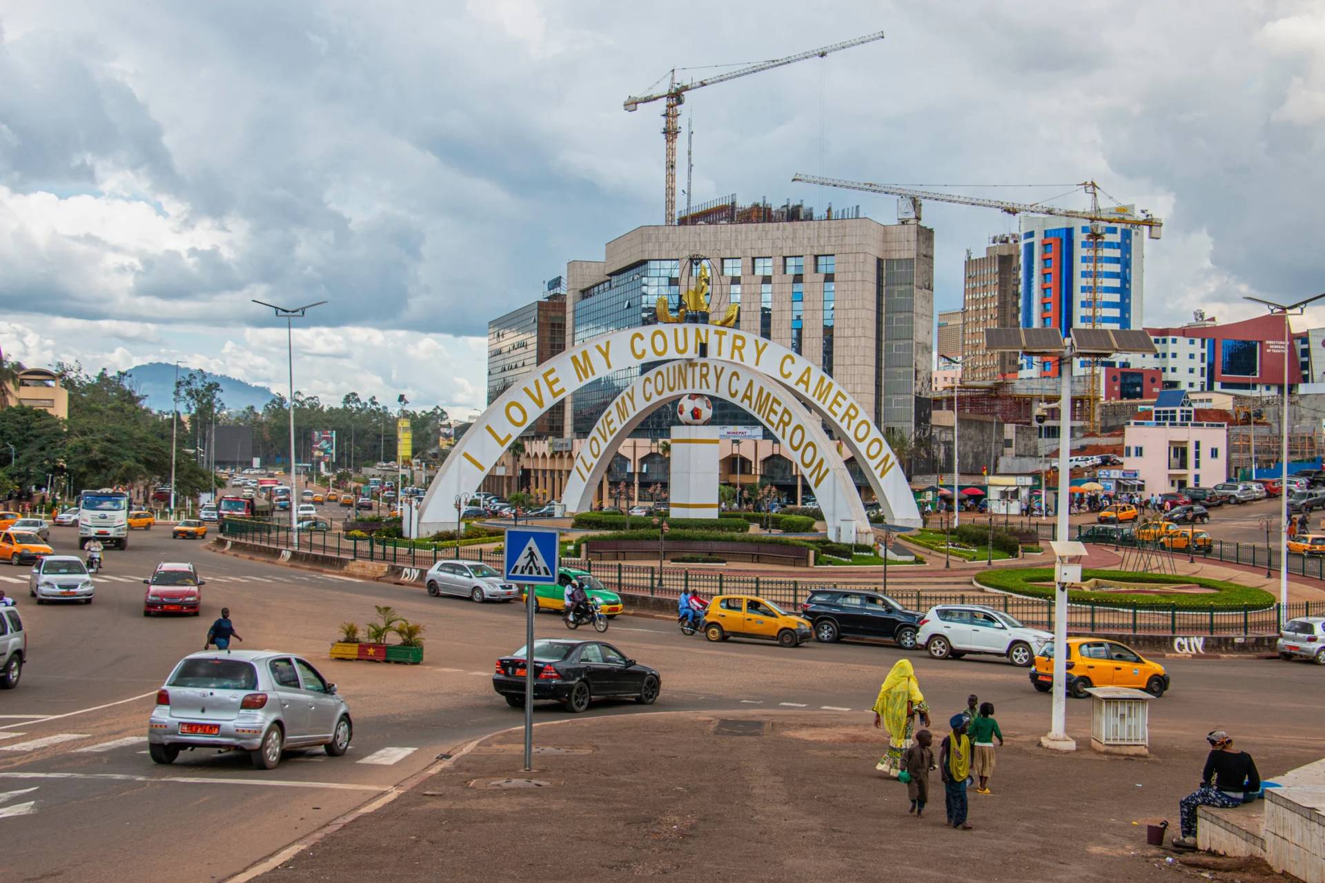 a busy street intersection near the iconic "I Love My Country" monument in Yaoundé, the capital city of Cameroon