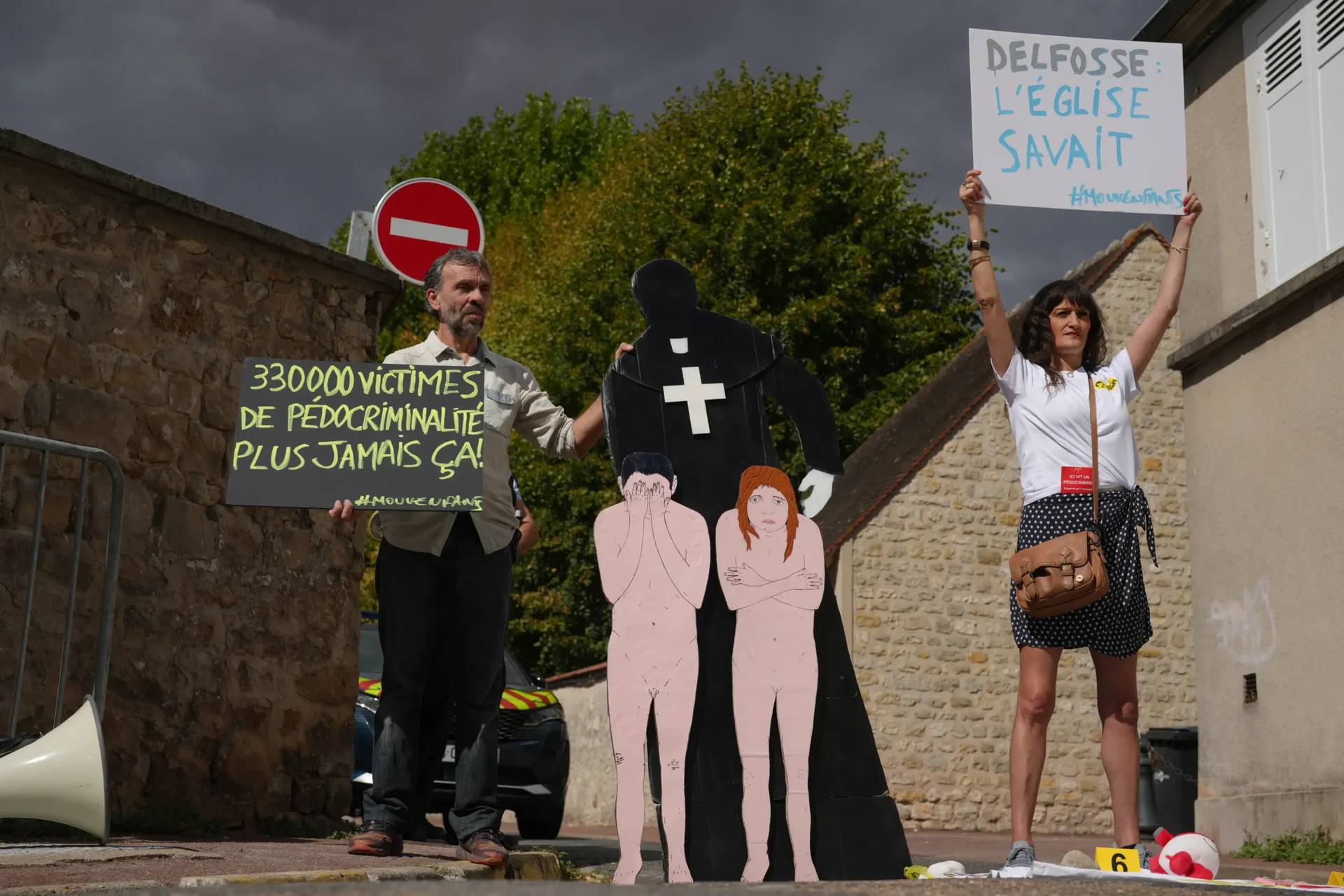 Activists fighting child abuse stage a protest near the home of a former Catholic priest suspected of sexually assaulting dozens of children, in Etrechy, outside Paris, Wednesday, Sept 16, 2026, Placards read from the left: '330,000 victims of child sexual abuse, never again' and Delfosse, the church knew'. (Credit: Thibault Camus/AP.)