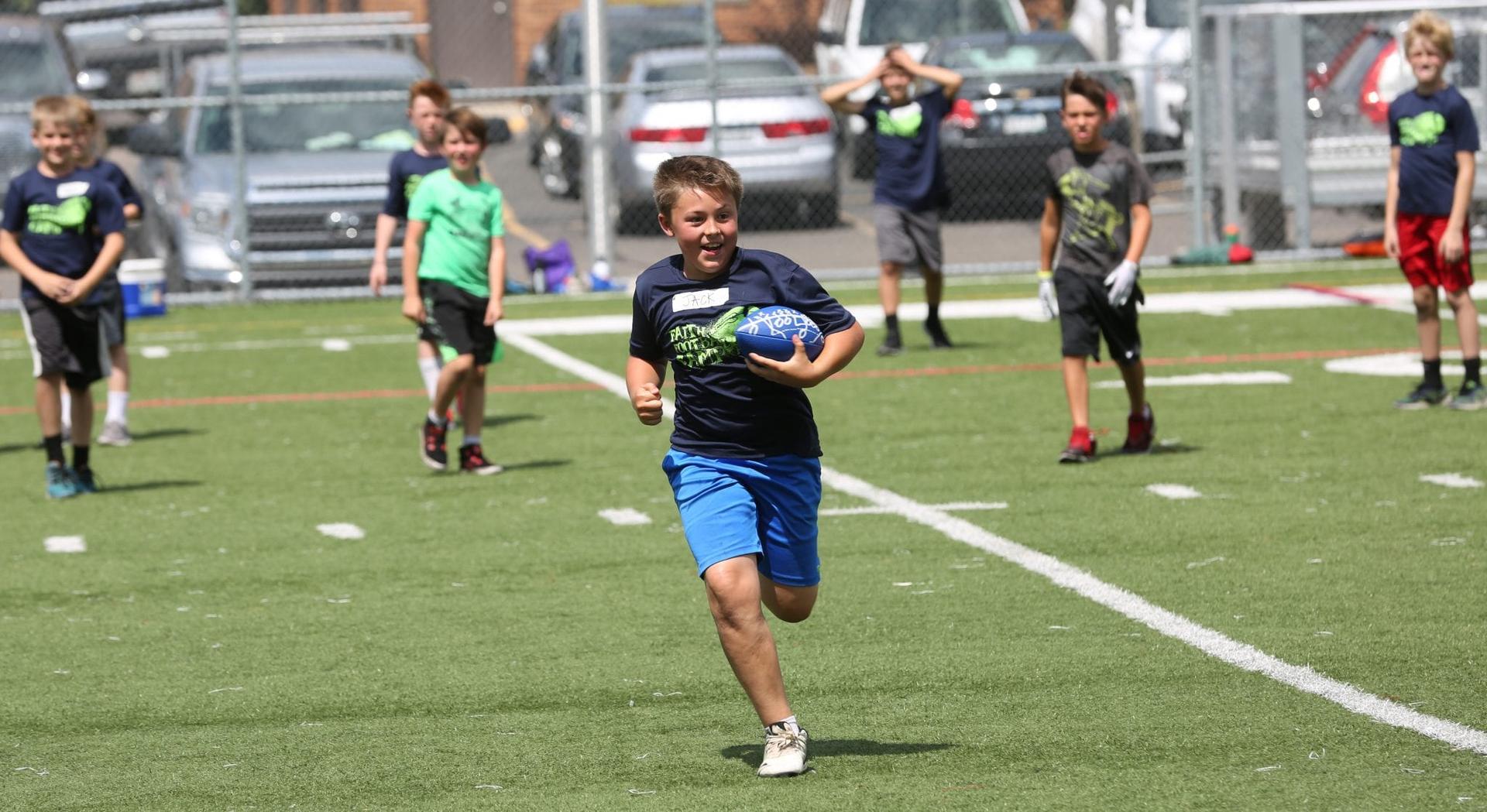 Summer camp combined football drills, scrimmages with Mass, adoration