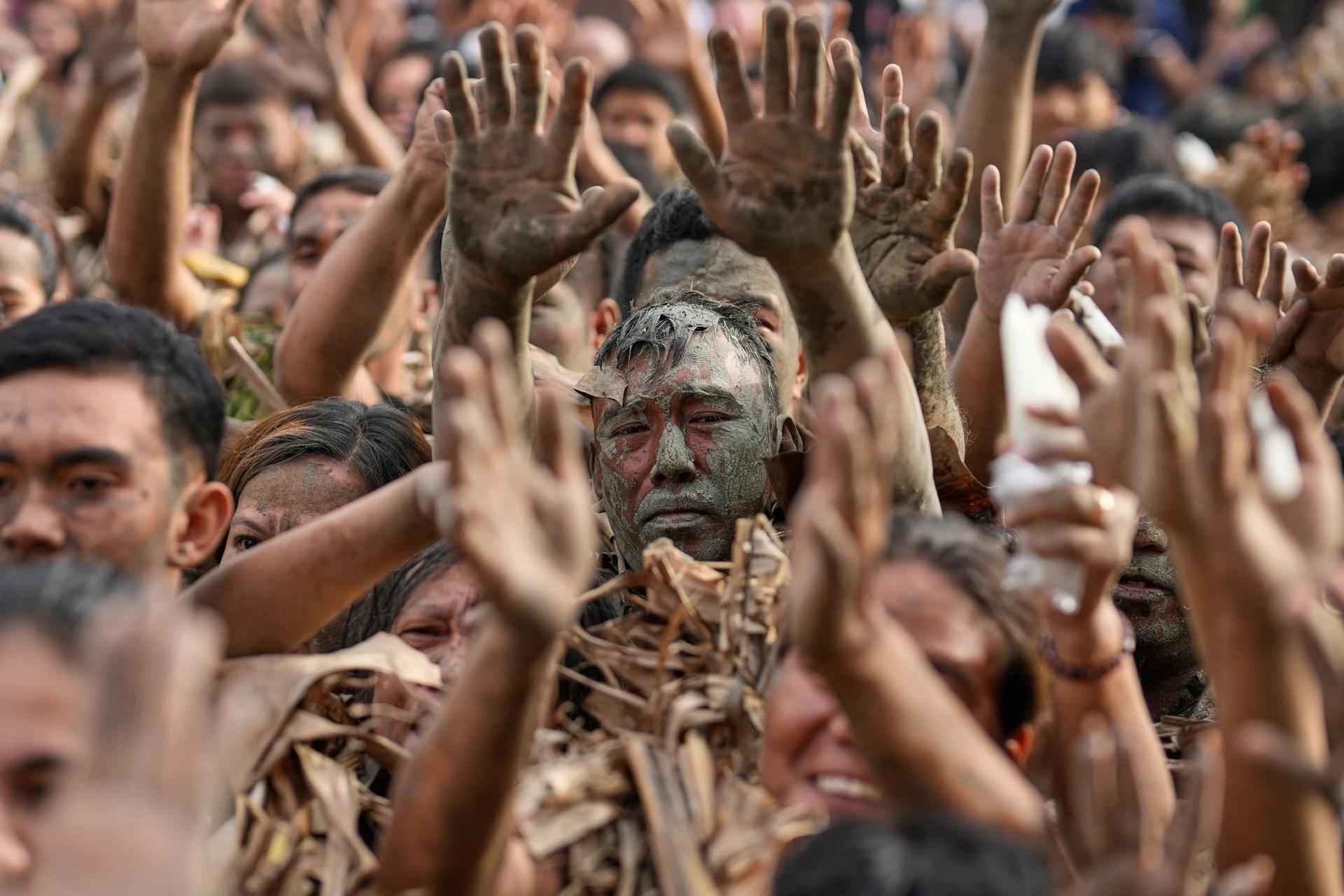 Photos show Philippine Catholics smearing mud on their bodies for festival honoring John the Baptist