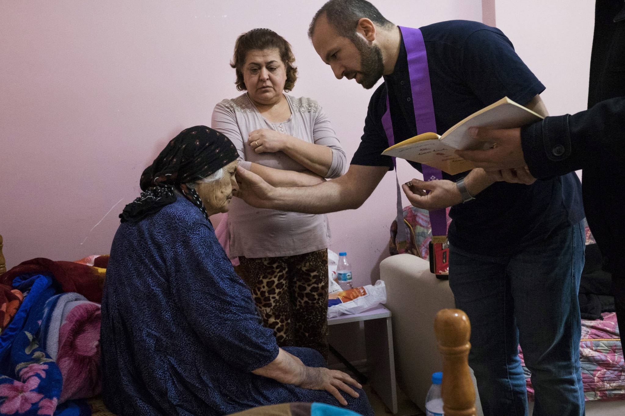 Chaldean Father Remzi Diril, also known as Father Adday, anoints Marta Kiryakos, a woman from Bartella, Iraq, who suffers from cancer, in this November 10 photo. (Credit: CNS photo/Oscar Durand.)